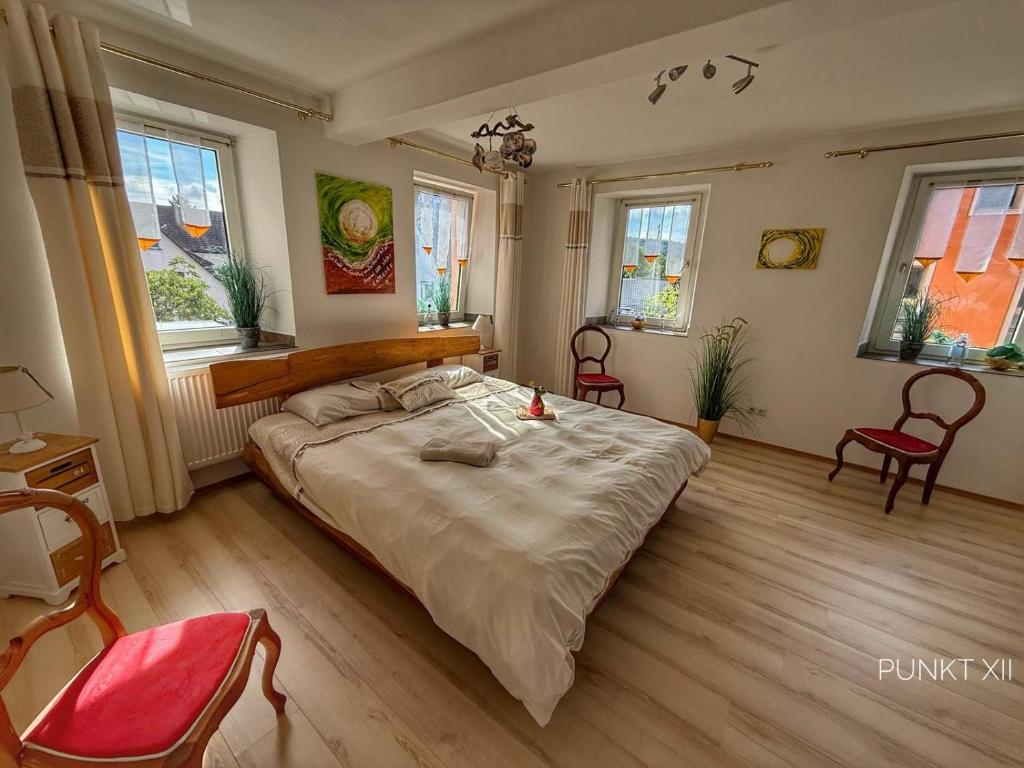 a bedroom with a large bed and two chairs at Wohnung 8 in Burghaslach