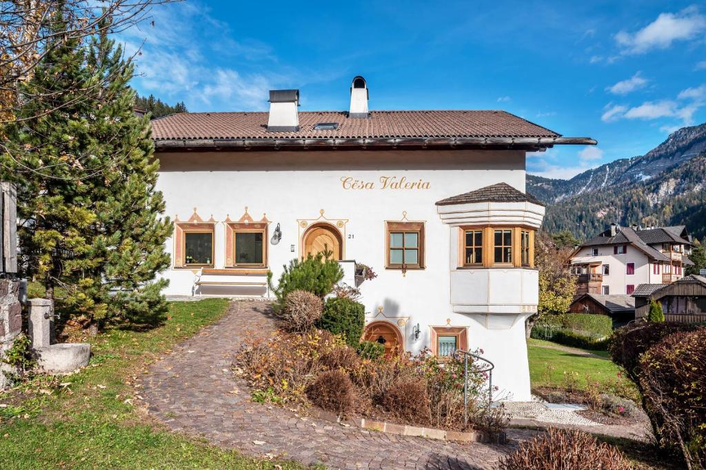 a house in the mountains with a pathway at Cesa Valeria App Sonia in Ortisei