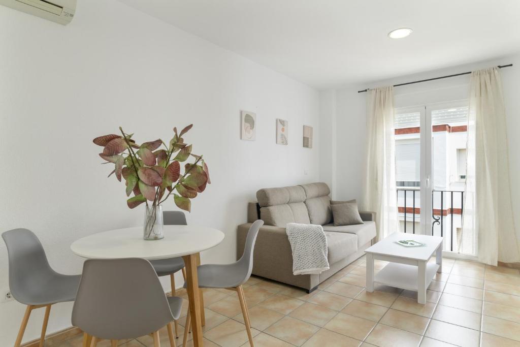 a living room with a table and a couch at Apartamento Perez Zara 7 in Conil de la Frontera