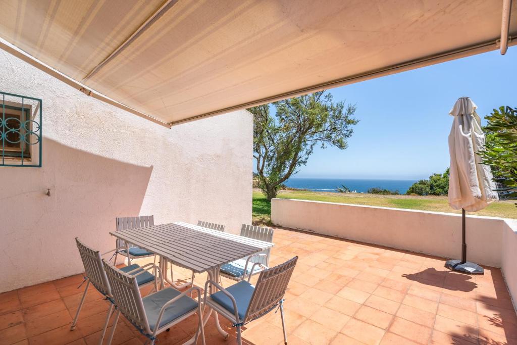 a patio with a table and chairs and an umbrella at Ocean Villa Algarve in Alvor