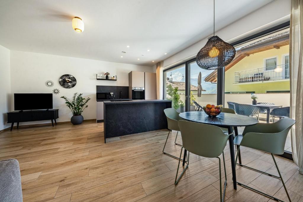 a dining room and living room with a table and chairs at Videre Lodge Wasserfall in Gargazzone