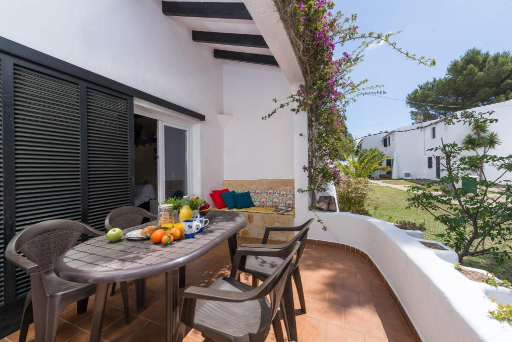 a patio with a table and chairs next to a pool at Cala Serena Beach 1 in Felanitx