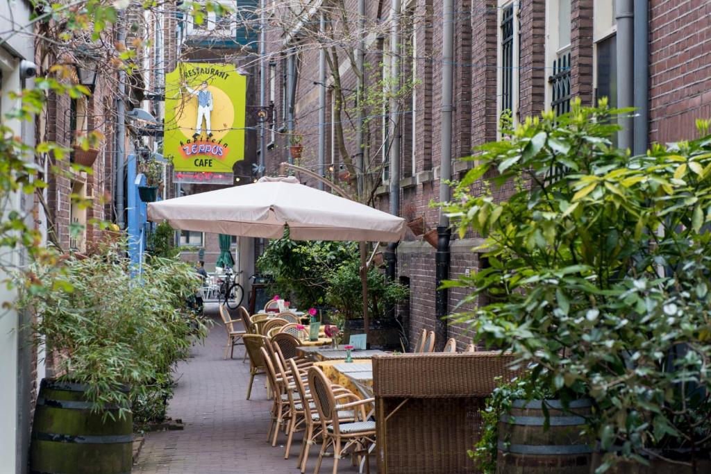 een tafel en stoelen met een parasol op een stoep bij Saint Claire Studio in Amsterdam