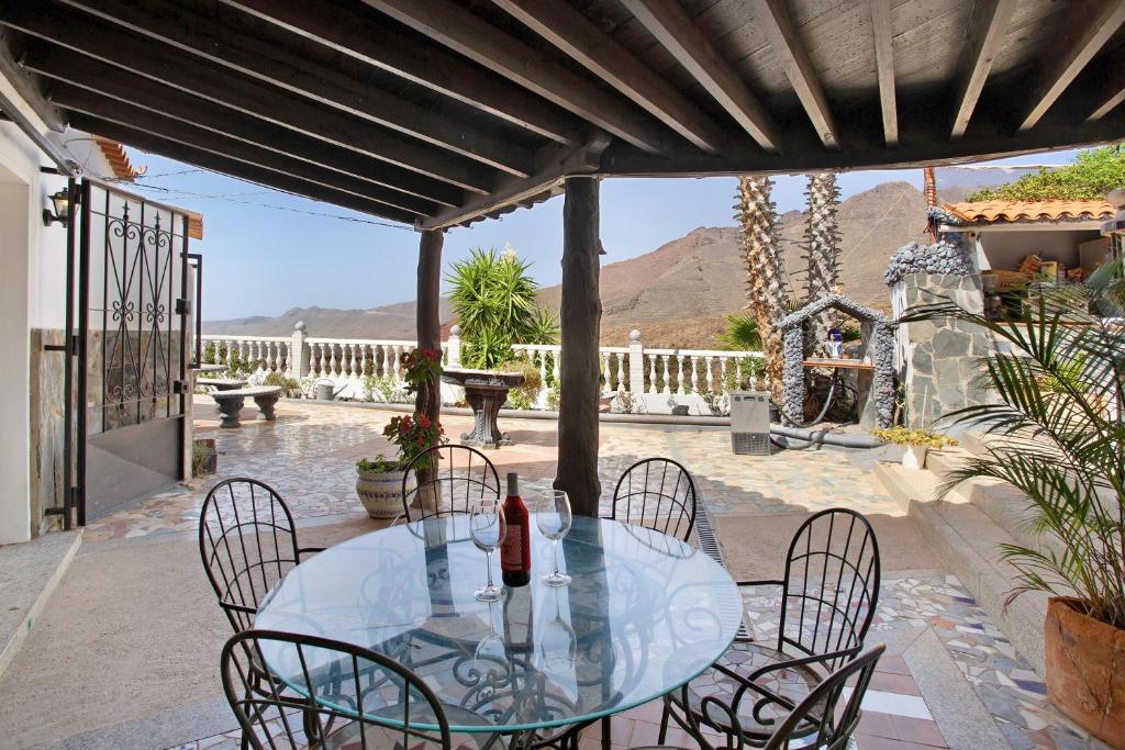 a glass table and chairs on a patio at Finca Fani 1 in Agüimes