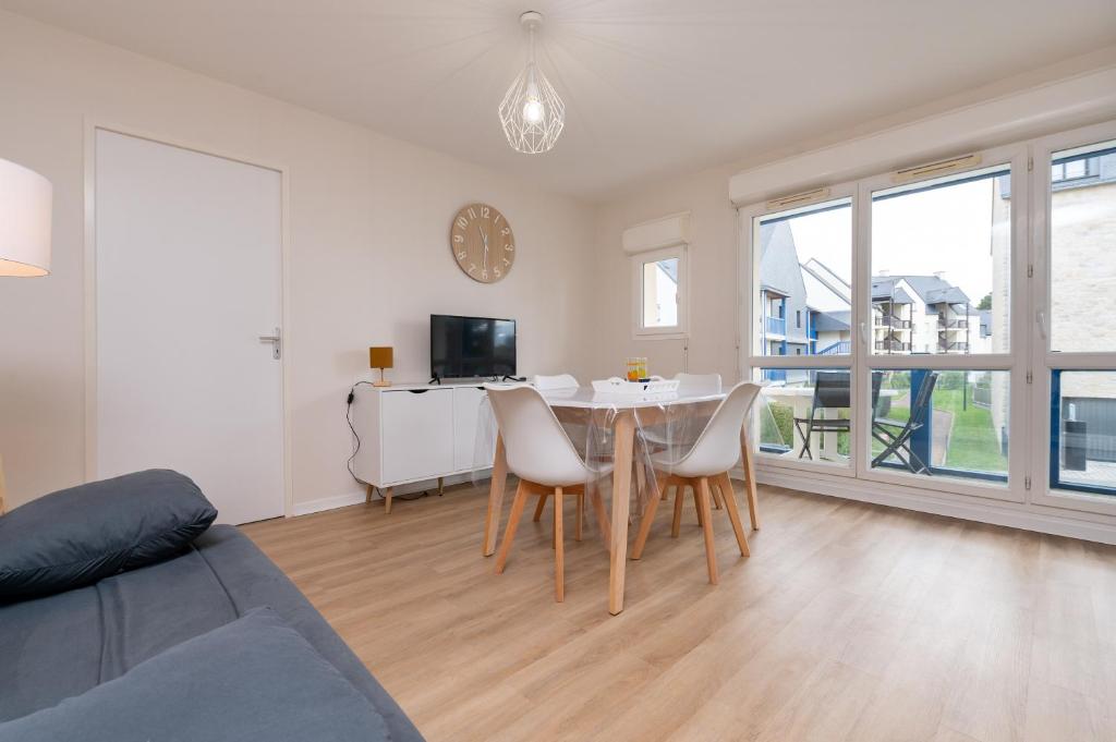 a living room with a table and chairs at L'Optimist, parking, proche plages in Arzon