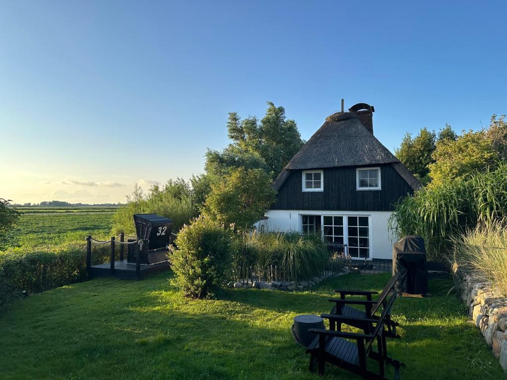 a black and white house with a thatched roof at Loft32 in Nordstrand