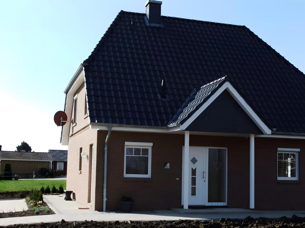 a house with a black roof at Ferienhaus Ferienhof Behnke in Heringsdorf
