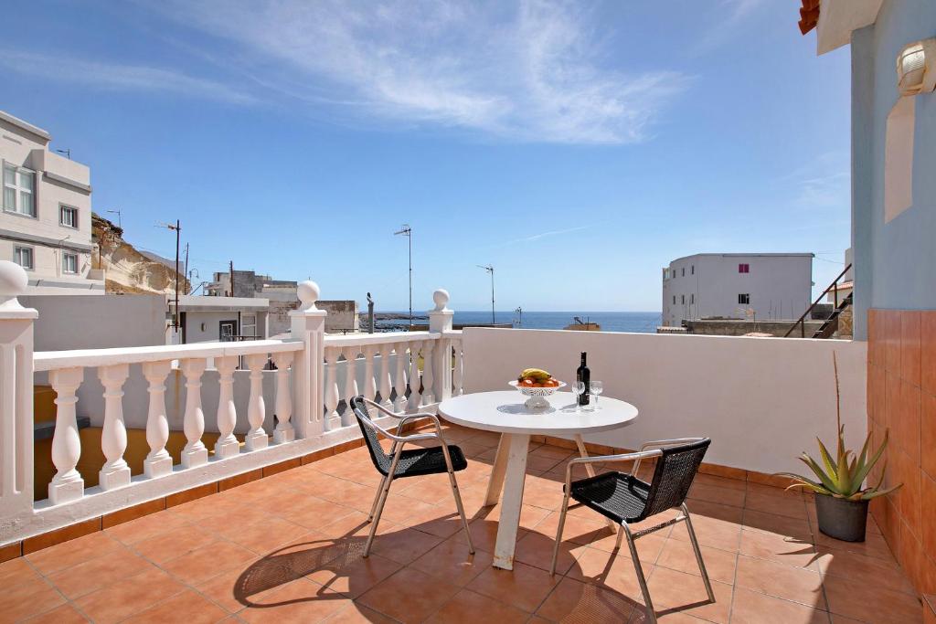 a table and chairs on a balcony with a view of the ocean at Atico Las Arenas in Arico