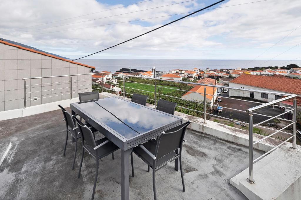 a table and chairs on a balcony with the ocean at Casa Branca in Ribeiras