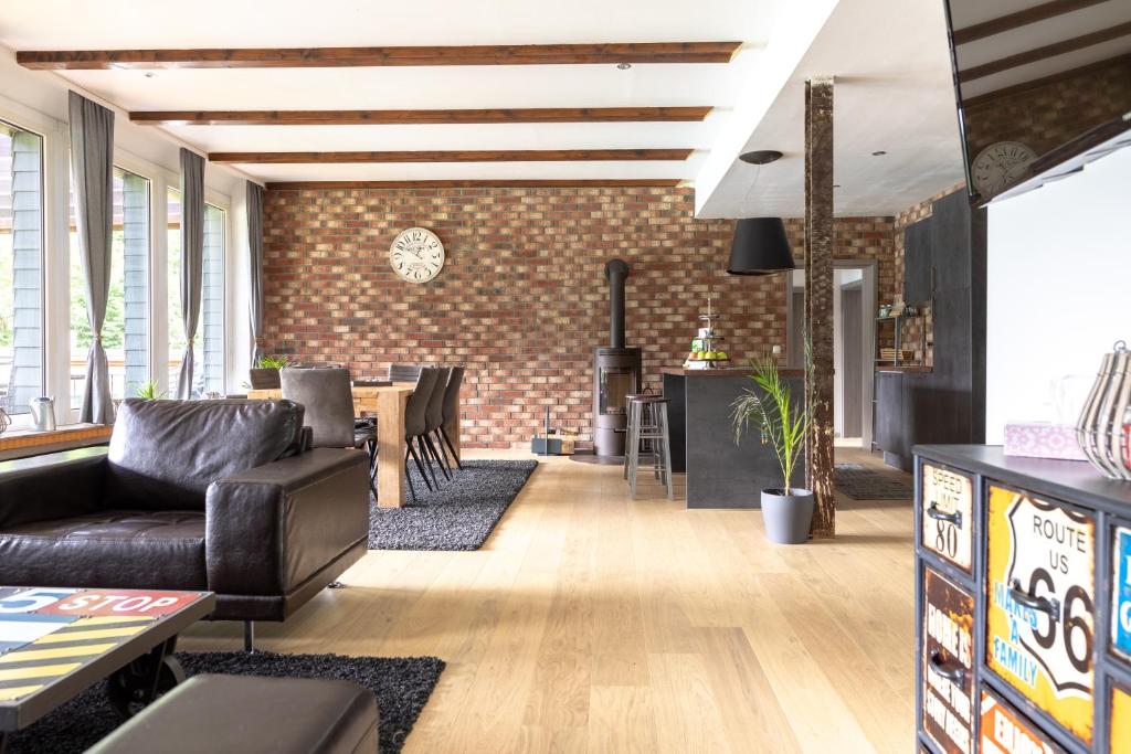 a living room with a couch and a brick wall at Fewo einzigartige Aussicht im Harz in Walkenried