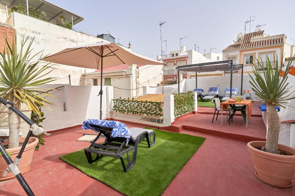 a patio with a table and chairs and an umbrella at Casa Victoria G in Nerja