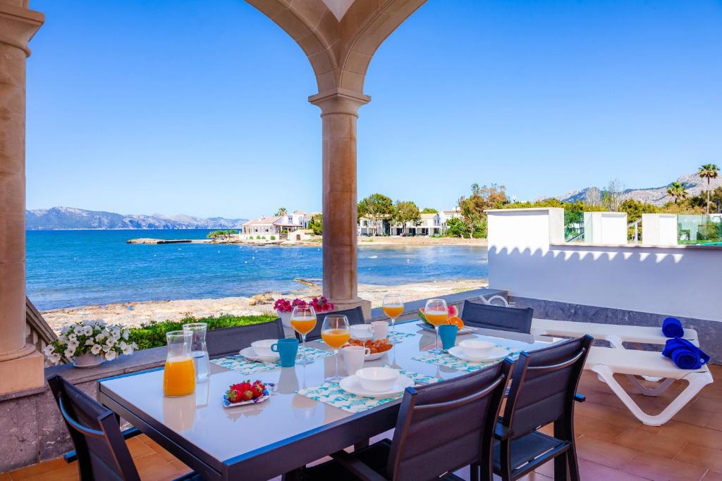 a table with glasses of orange juice and a view of the ocean at Villa Cas Siulet in Alcudia