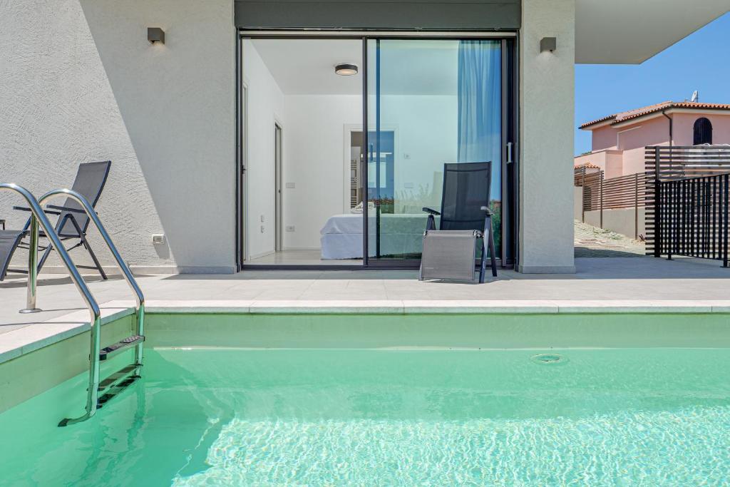 a swimming pool with a view of a house at Villa Mirtina - by And Service in Golfo Aranci