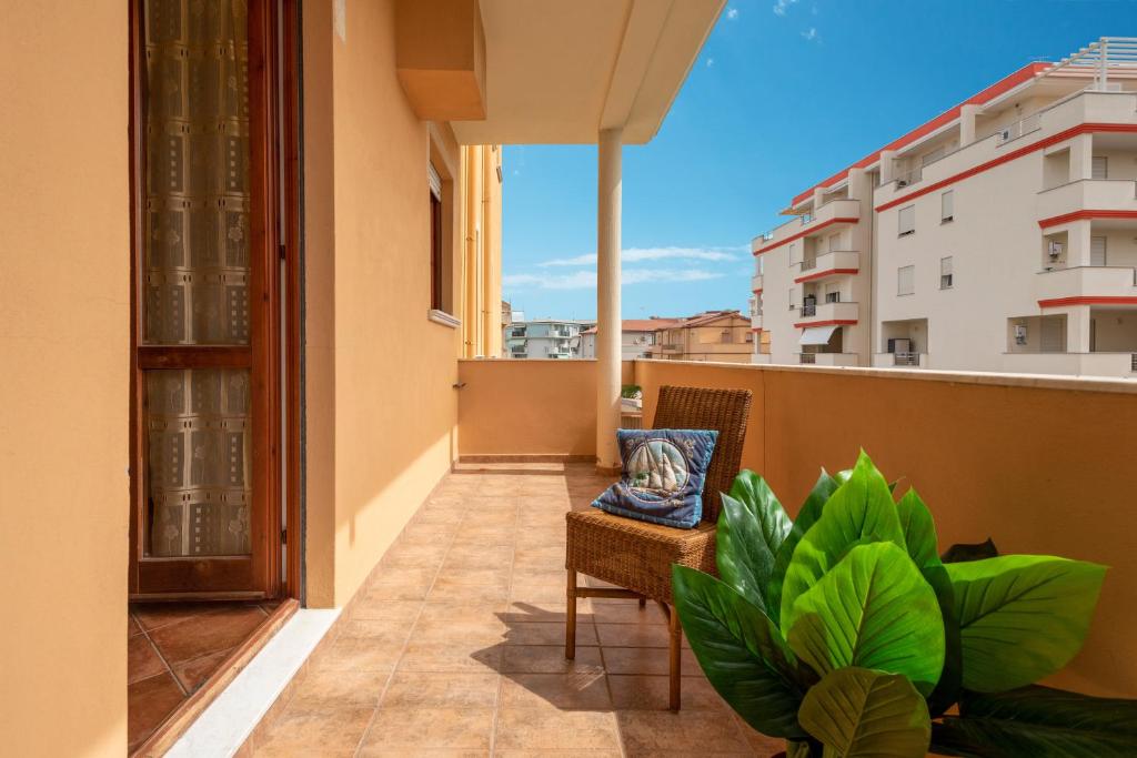 a balcony with a chair and a plant at Villafiorita in Alghero