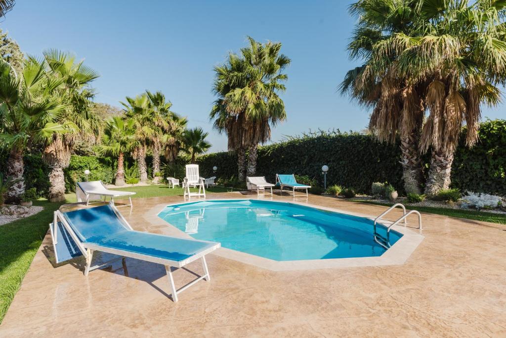 a swimming pool with a blue chair and avisorvisor at Casa Margiulu’ - Partanna in Partanna