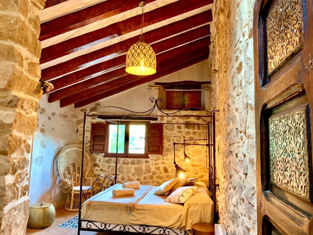 a bedroom with a bed in a stone wall at La Casuca in Olba