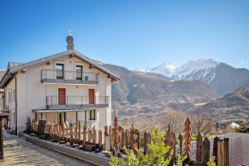 a house with a fence and mountains in the background at Verger Plein Soleil in Saint-Pierre