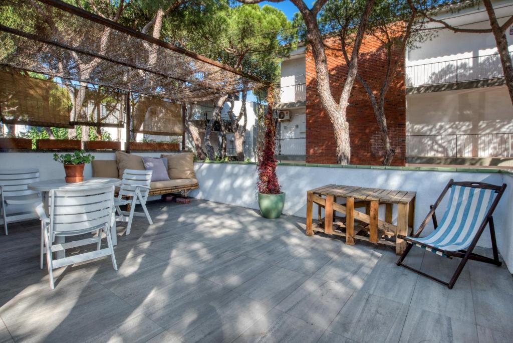 a patio with chairs and a table and a couch at Old Side Duplex Platja d Aro in Platja d'Aro