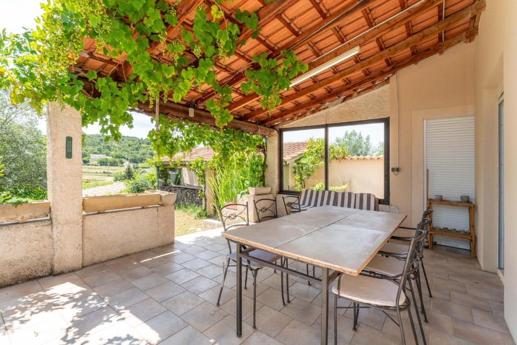 a patio with a wooden table and chairs on it at Maison Avec Vue Sur Le Ventoux in Faucon
