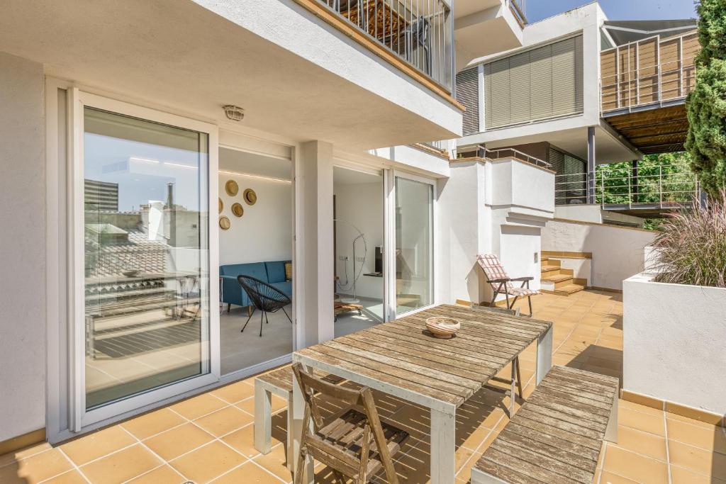 an outdoor patio with a wooden table and chairs at Apartamento L'escala - Bajos in L'Escala