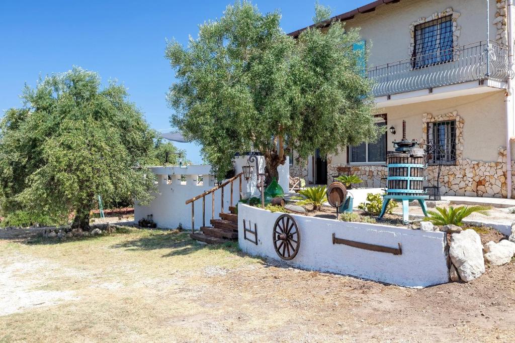 a house with a tree in front of it at Casale- Il Giglio Rosa in Sorso