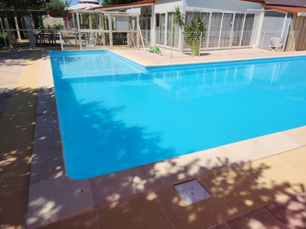 a swimming pool with blue water in front of a house at Marinière in Sainte-Croix-de-Verdon