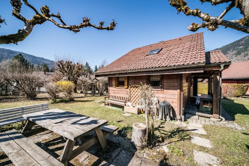 a wooden cabin with a picnic table and a bench at Chalet 6p Classique-Les Ajoncs d'or in Verchaix