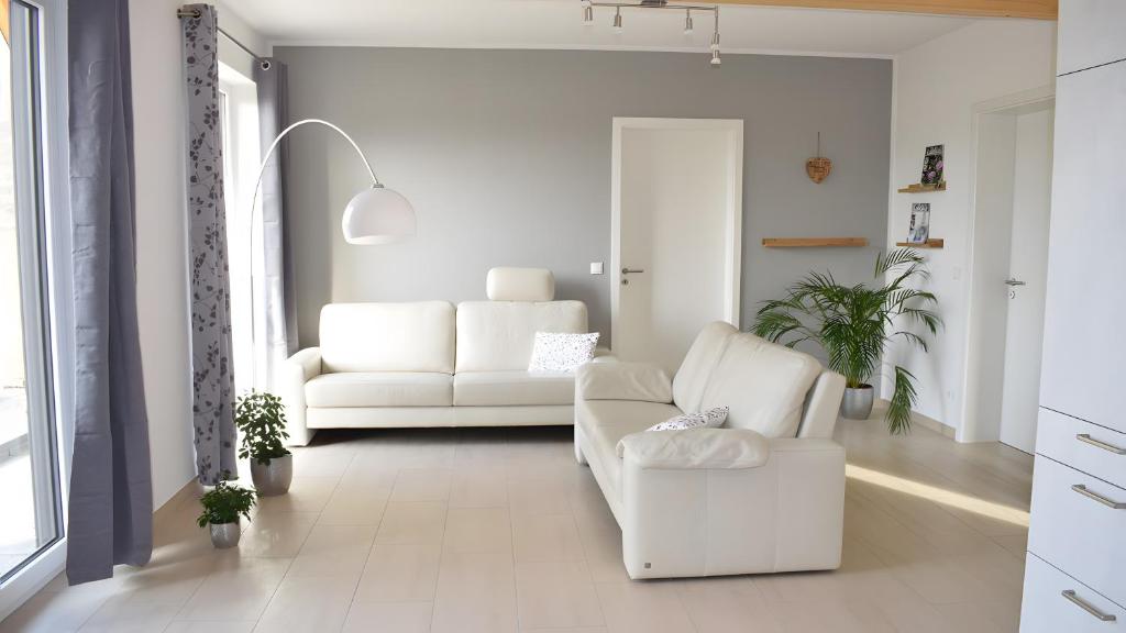 a living room with a white couch and a chair at Ferienwohnung Wilhelmshof in Sinzig