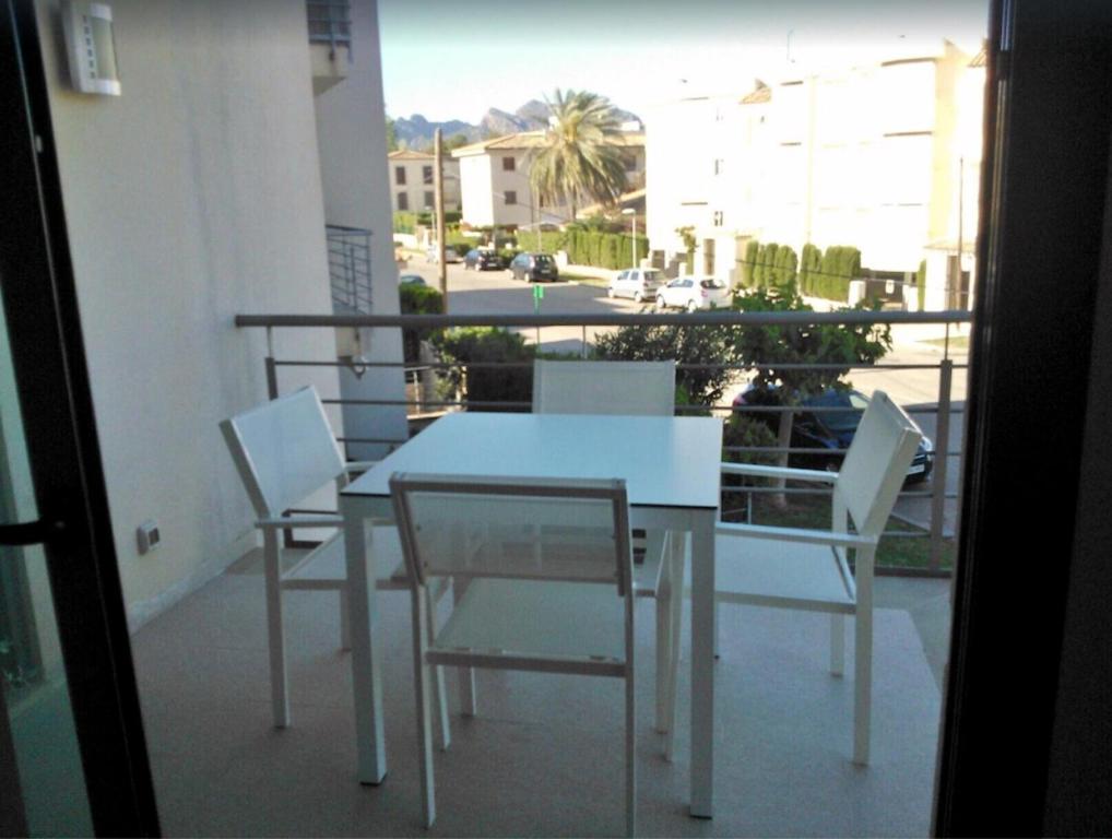 a white table and chairs on a balcony at Apartamento Llenaire in Pollença