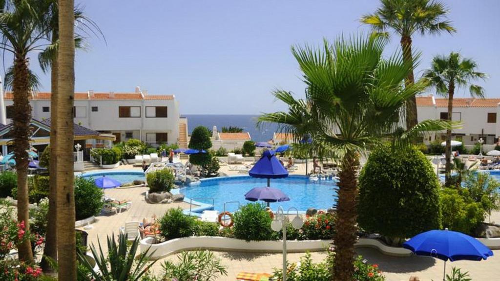 a view of a resort with a pool and palm trees at Magnific 3-bedroom beach Bungalow in Adeje