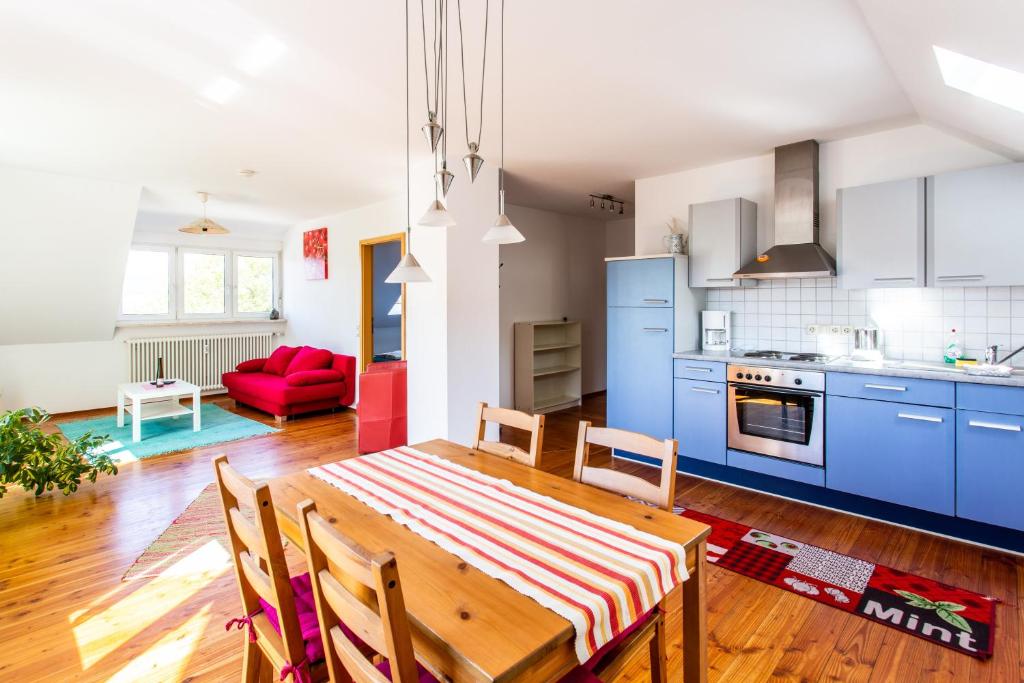 a kitchen and dining room with a wooden table and blue cabinets at Elstar in Stockach