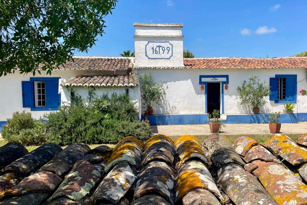 a building with a clock on the side of it at Sesmarias Dos Nobres in Azinheira dos Barros
