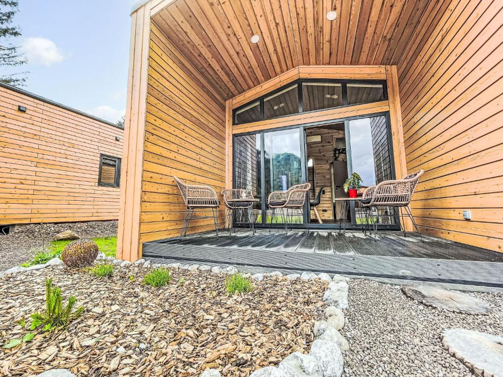 a house with a patio with chairs on it at Holiday Home Tiny Haus Glockenalm-Haus zum Glück by Interhome in Aurach