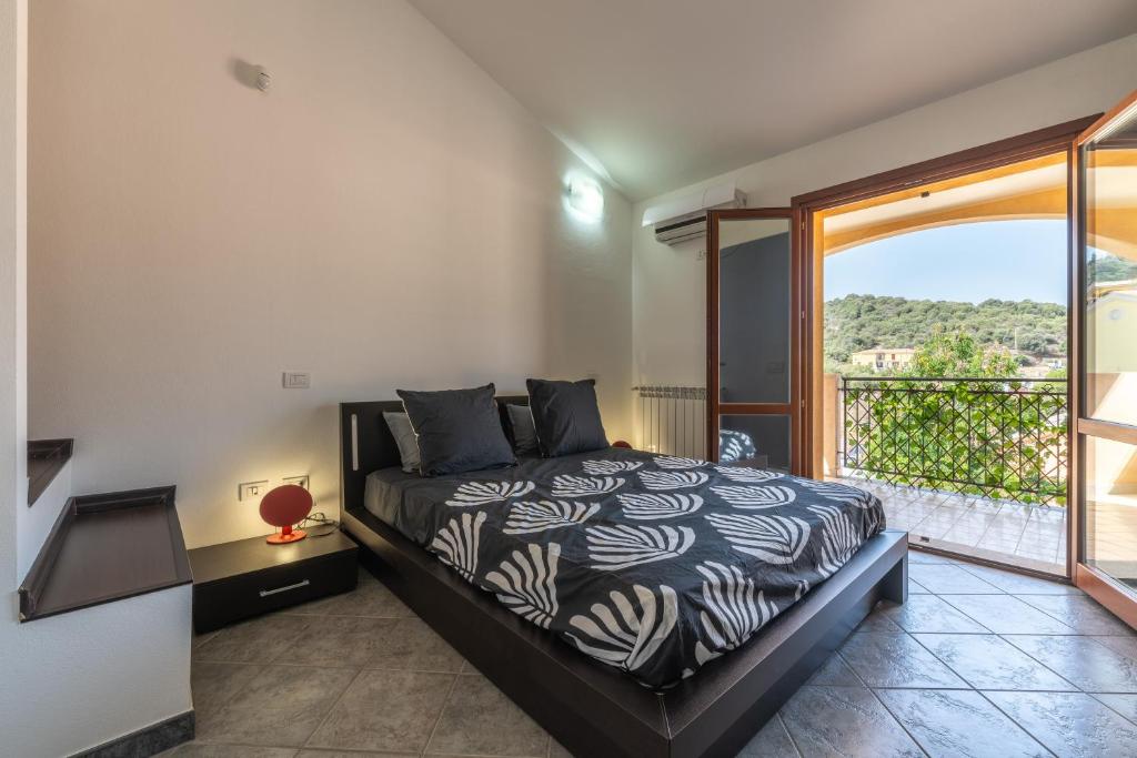 a bedroom with a bed and a balcony at Casa Annabella in Sarroch