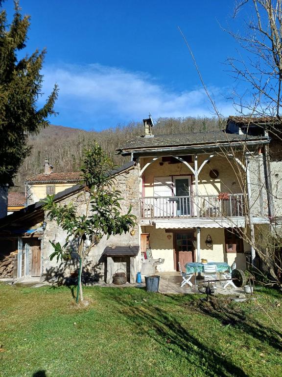 a large stone house with a balcony and a yard at Maison Typique De Montagne in Ercé