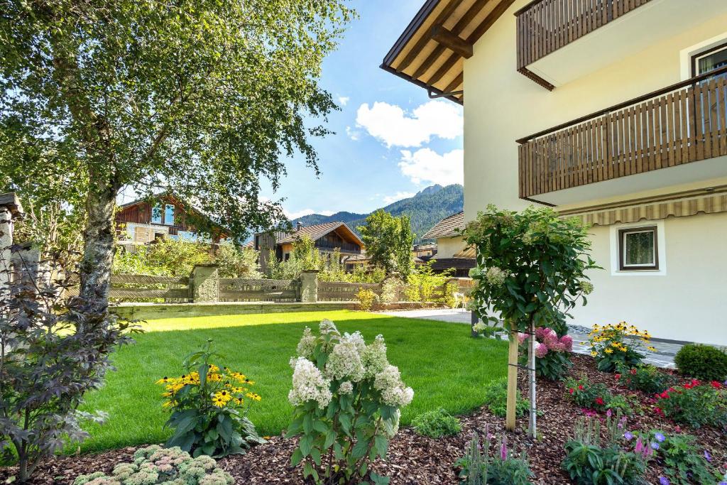 a garden with flowers in the yard of a house at Premium App Hofer Monika in Villabassa