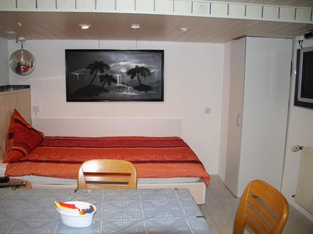 a bedroom with a bed and a table and chairs at Gästezimmer Jülich mit Küche in Weil am Rhein