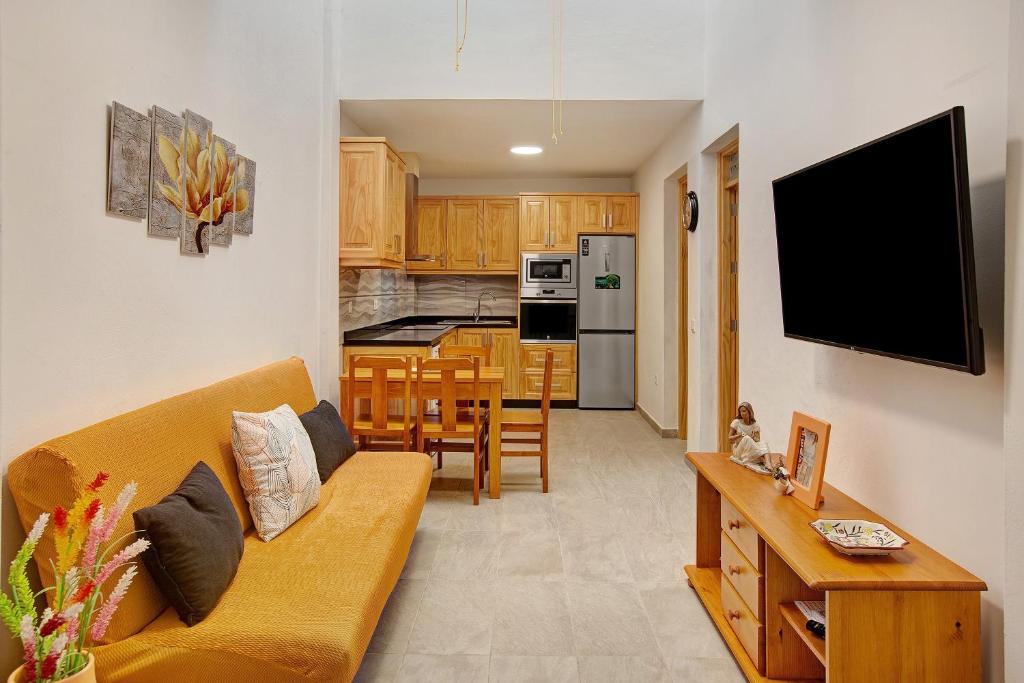a living room with a couch and a kitchen at Arinaga Home in Arinaga