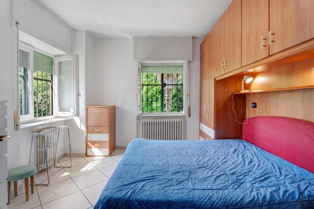 a bedroom with a blue bed and two windows at Unique Lake View In Green Park in Nebbiuno