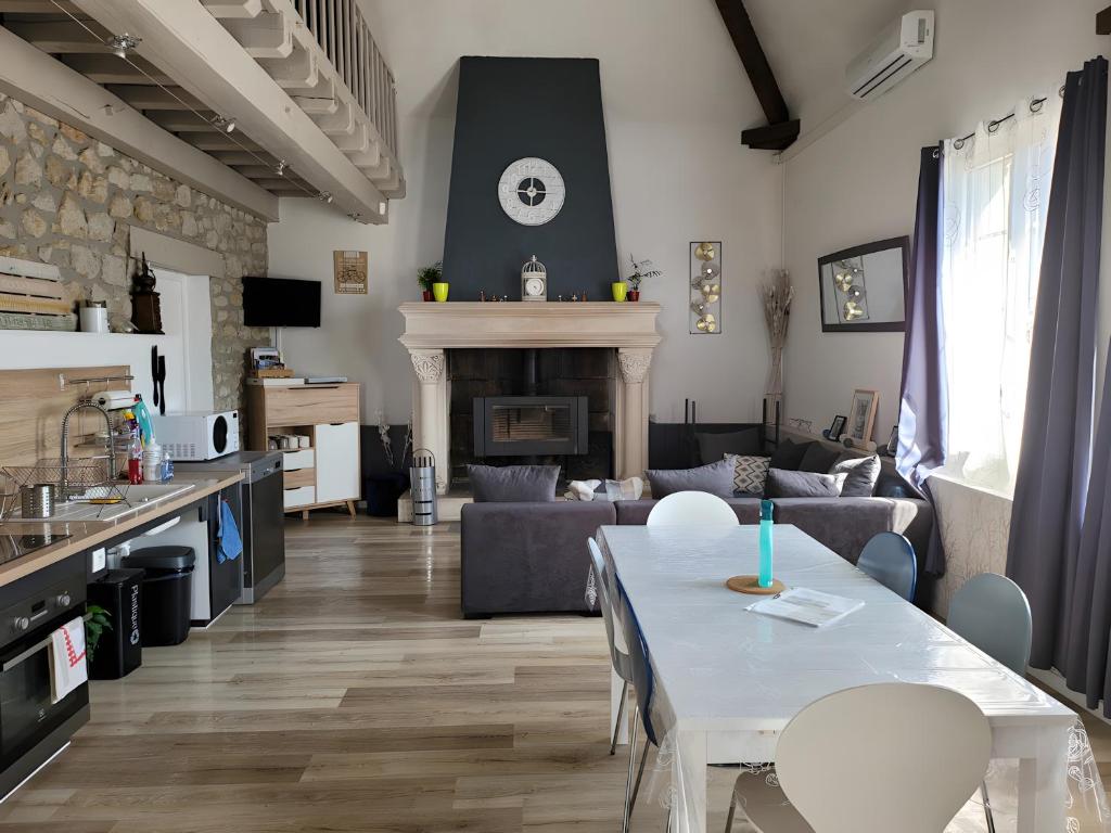 a living room with a table and a fireplace at Gite des Coteaux Pmr in Sainte-Maure-de-Touraine