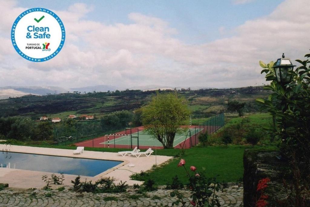 a sign that says clean and safe next to a tennis court at Casa do Mogadouro in Mesquitela