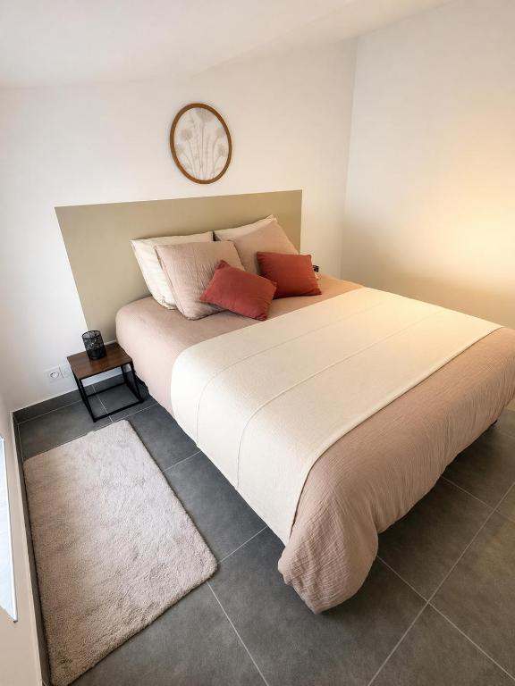 a bedroom with a large bed with a clock on the wall at Appartement Andance in Andance