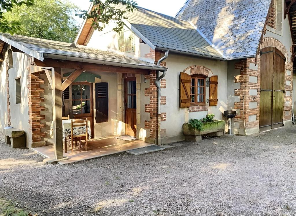 a brick house with a porch and a door at Le Chalêt La Neverdiere in Ygrande