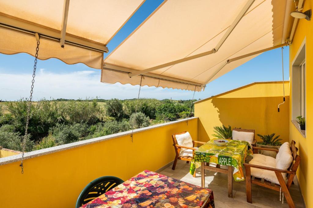 a balcony with a table and chairs and umbrellas at Domus Luna in Giba