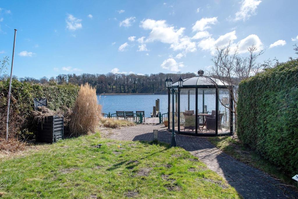 a gazebo in the grass next to a body of water at Moewentraum in Malchow