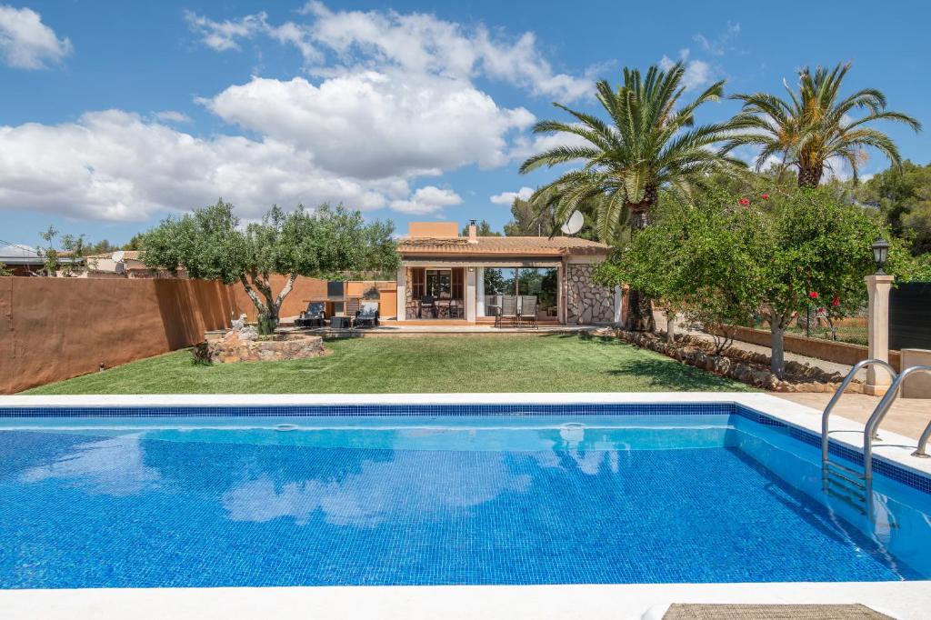 a villa with a swimming pool and a house at Capricho in Islas Baleares