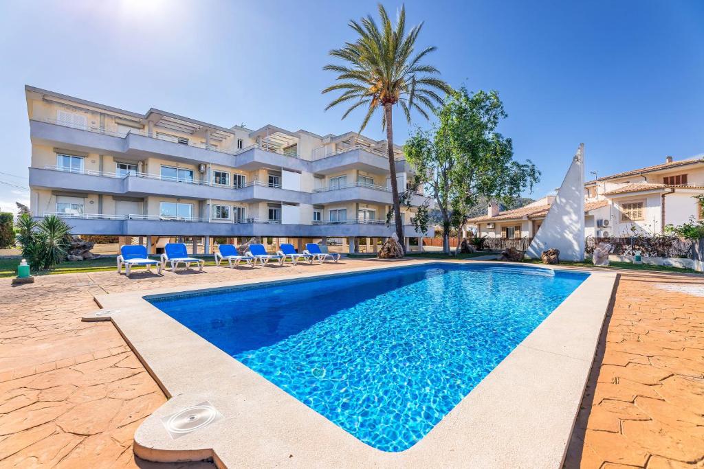 a swimming pool in front of a building at Apartamento Veleta Puerto Pollensa in Pollença