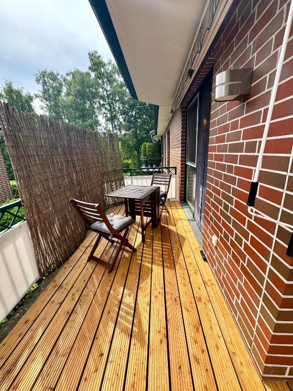 a patio with a table and chairs on a wooden deck at Citynah und Chic bei Hamburg in Norderstedt