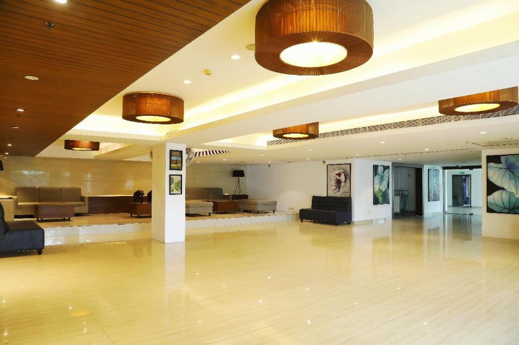 a lobby with a large lobby with couches and tables at Banyan Palace in Chennai