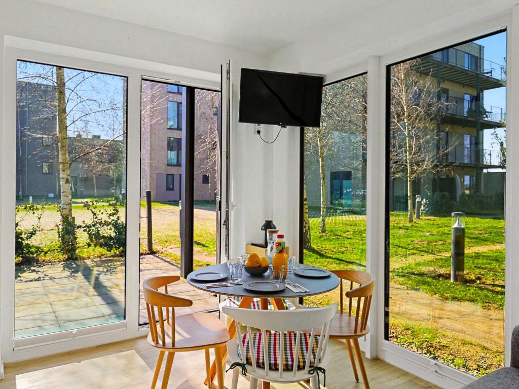 a dining room with a table and chairs and sliding glass doors at Apartment Seemomente - 615 by Interhome in Lembruch